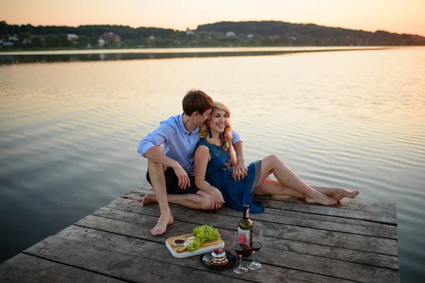 男人和女人在湖边的码头野餐 — 图库照片