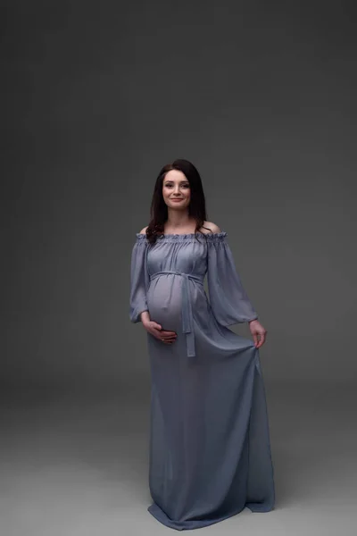 Una Joven Embarazada Con Vestido Está Pie Sobre Fondo Gris — Foto de Stock