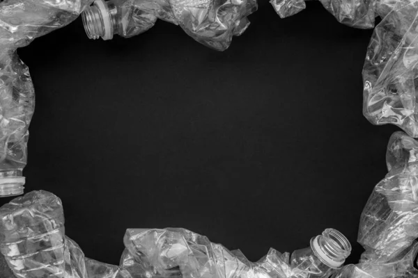 Çevre Koruma Temasını Geliştirin Siyah Arka Planda Sıkıştırılmış Plastik Şişeler — Stok fotoğraf