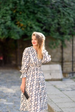 Elinde küçük bir çantayla genç ve güzel bir kadın..