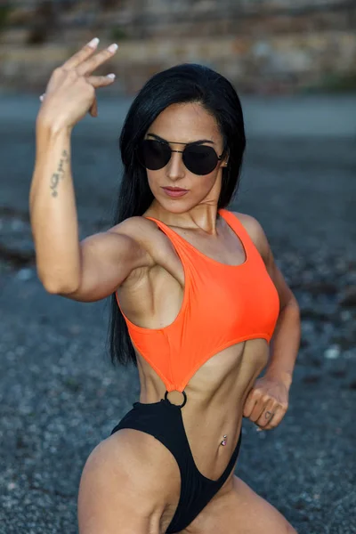 Fitness dziewczyna stwarzające z pięknym czarnym i pomarańczowym bikini — Zdjęcie stockowe