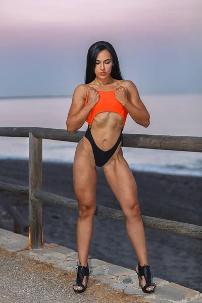 Fitness menina posando com um belo biquíni preto e laranja — Fotografia de Stock