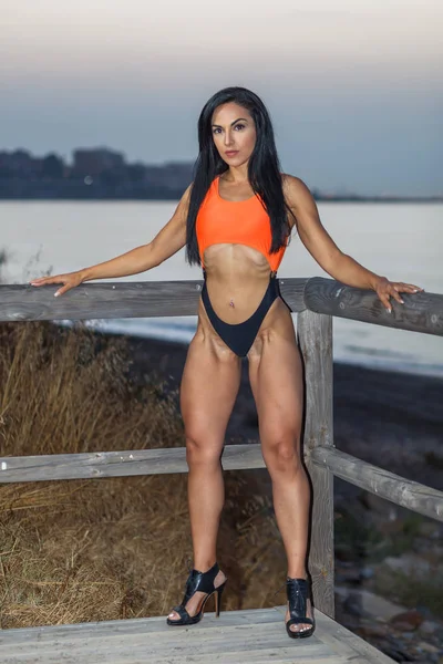 Chica de fitness posando con un hermoso bikini negro y naranja —  Fotos de Stock