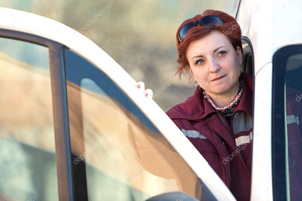 Female paramedic worker opened emergency car door and looking away