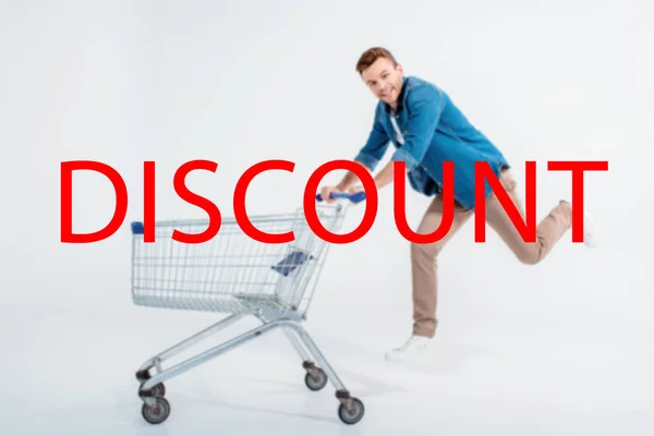 Happy Young Man Running Shopping Trolley Smiling Camera Grey Discount Stock Image