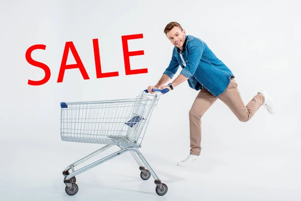 Happy Young Man Running Shopping Trolley Smiling Camera Grey Sale Stock Photo