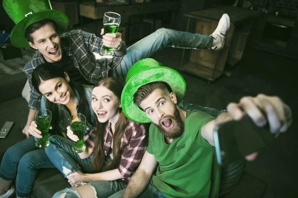聖パトリックの日に Selfie を作ってビールで幸せな友人のグループのハイアングル ストック画像