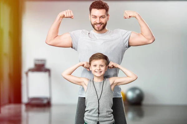 Niño Feliz Con Padre Mostrando Los Músculos Cámara Imagen De Stock