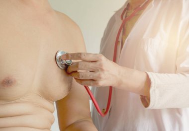 Kadın doktor stetoskop onay ve kalp ve akciğerler bir hastanenin hastası dinle için kullanma.