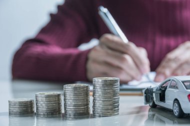 Araba sigortası ve araba Servisi. İşkadını deste paralar ve oyuncak araba, iş ve finansal kavramı ile.