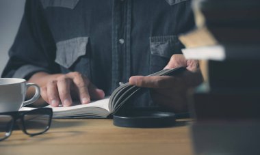 Masanın üzerine bir kitap okuma adam. Eğitim ve insan kavramı.