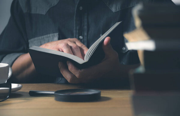 Man reading a book on the table. Education and people concept.