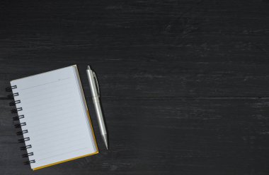 Üstten görünüm açık kitap. Metin ekle için ahşap arka plan ve kopya alanı üzerinde kalem ile açık kitap.