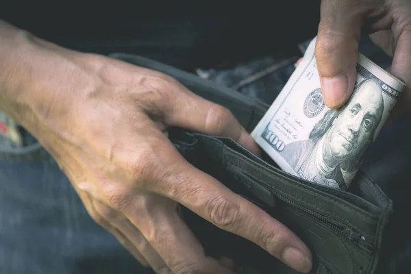 Hand holding a banknote in wallet for financial, accounting and saving money concept.