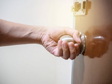 Açılış ya da kapaliniş belgili tanımlık kapı kapı kolu, tutan eli yakın çekim.