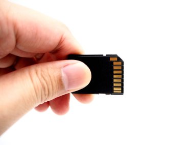 Beyaz arka plan üzerinde izole bir bellek kartı tutan el.