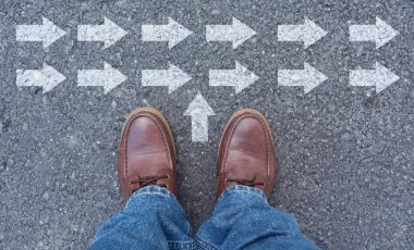 Üstten görünüm oklarla işaretlenmiş bir yol seçerek ayakkabı giyen adam. Doğru yolu kavramı seçer.