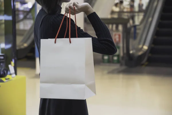 Young Asian woman holding shopping bag in shopping mall. Shopping concept.