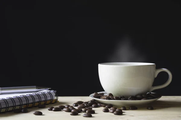 Una taza de café con granos de café sobre la mesa de madera con copia sp — Foto de Stock