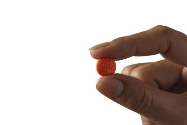 Beyaz arka planda izole edilmiş beyaz bir hap tutuyor..