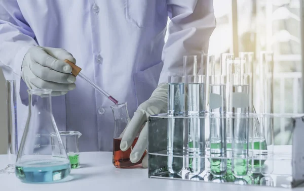 Pesquisador com tubos de ensaio químicos de laboratório de vidro com líquido — Fotografia de Stock