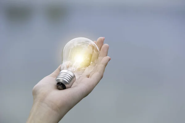 Innovazione e concetto creativo di mano tenere una lampadina e co — Foto Stock