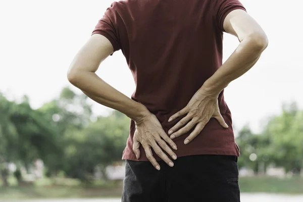Una mujer que sufre de dolor de espalda, lesión espinal y problemas musculares —  Fotos de Stock