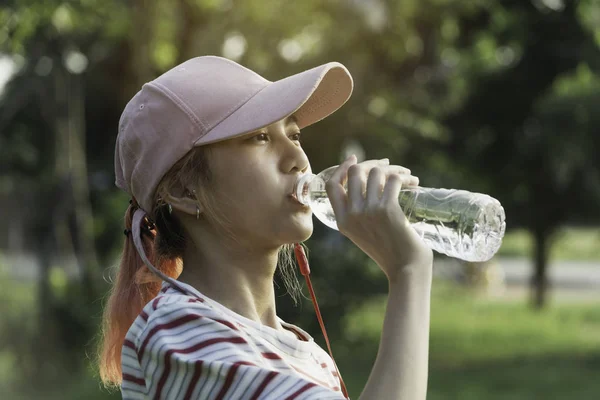 Крупним планом жінка п'є воду з пляшки після вправ . — стокове фото