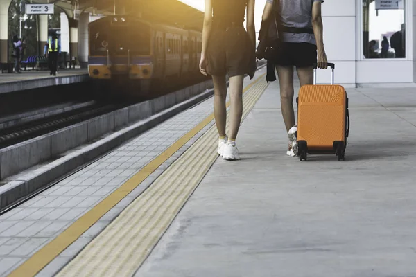Mujer arrastrando maleta naranja maleta de equipaje, caminando en tren sta —  Fotos de Stock