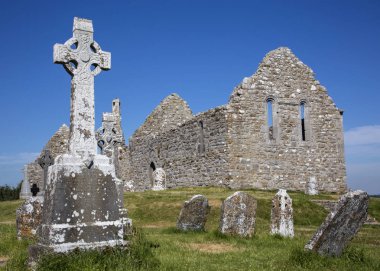 Clonmacnoise Cathedral  with the typical crosses and graves. The monastery ruins. Ireland clipart