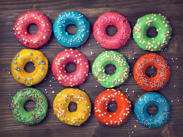 Donuts Coloridos Fundo Marrom Madeira — Fotografia de Stock