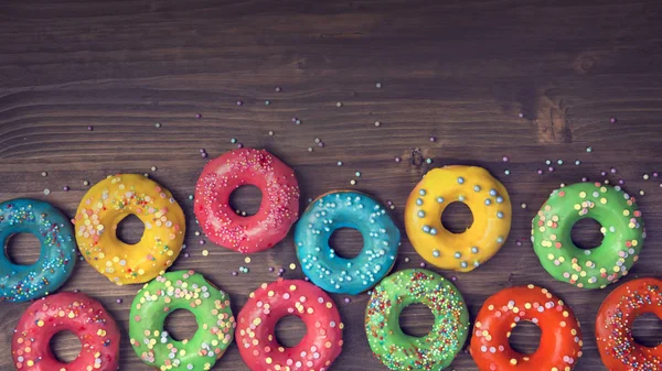 Donuts Coloridos Fundo Marrom Madeira — Fotografia de Stock