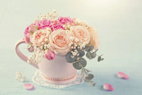 パステル ブルーの背景に茶碗のピンクのバラ — ストック写真