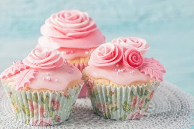 Cupcake mavi ahşap arka plan üzerinde pembe çiçekli
