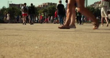 güneşli sokakta yürüyen insan kalabalığı