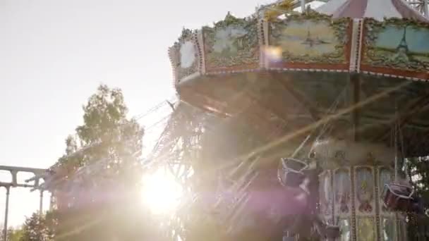 Promienie słońca wpadające przez Swing jeździć w parku rozrywki — Wideo stockowe