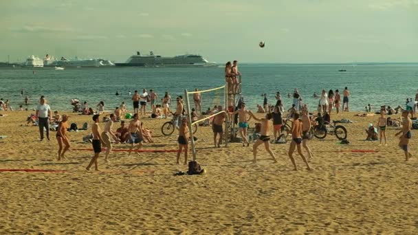 İnsanlar gün batımında sahilde voleybol oynamak. — Stok video