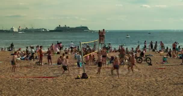 İnsanlar gün batımında sahilde voleybol oynamak. — Stok video