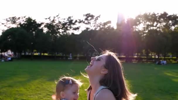 Joyeux jeune mère jouant à l'extérieur avec son petit bébé — Video