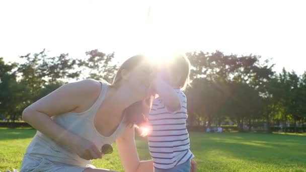 Gelukkig jonge moeder spelen buiten met haar kleine baby — Stockvideo