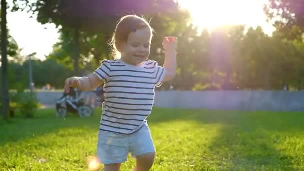 Schattig klein babymeisje wandelingen door gras — Stockvideo