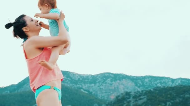彼女の小さな女の赤ちゃんと若い母親は夏の日にビーチでの楽しみを持っています 幸せな家族のコンセプト 幸せな子供時代フル ビデオ映像 — ストック動画