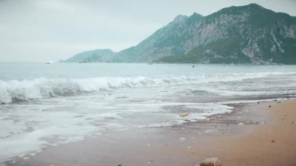 Dalgalar Deniz Köpüğü Arka Planda Dağlar Ile Kumlu Bir Deniz — Stok video