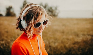 Beyaz kulaklık müzik parkta güzel ve genç birbayan. Rahat tarzı kavramı