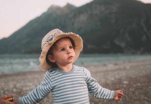 Linda niña con sombrero jugando en una playa en el día de verano. Viajes en familia y concepto de vacaciones —  Fotos de Stock