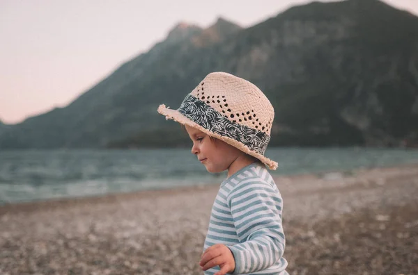 Linda niña con sombrero jugando en una playa en el día de verano. Viajes en familia y concepto de vacaciones —  Fotos de Stock