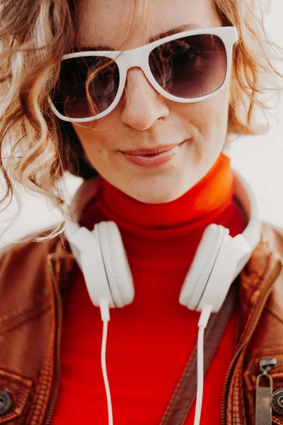Krásná mladá žena v neformálním oblečení s bílými sluchátky v letním dni — Stock fotografie