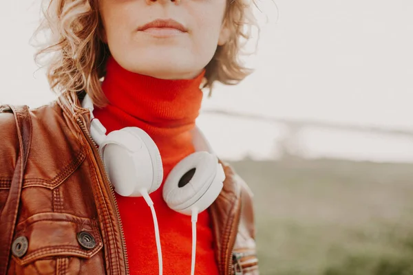 Mulher bonita em roupas casuais com fones de ouvido brancos no dia de verão — Fotografia de Stock