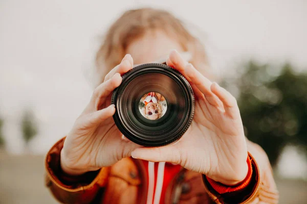 Fiatal nő keresi a kamera lencséje. Fotózás és a művészet fogalmát — Stock Fotó