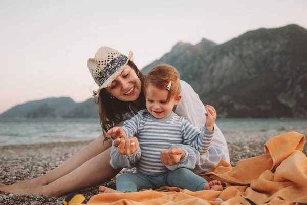 Милая маленькая девочка с матерью, играющей на пляже в летний день. Концепция семейного путешествия и отдыха — стоковое фото